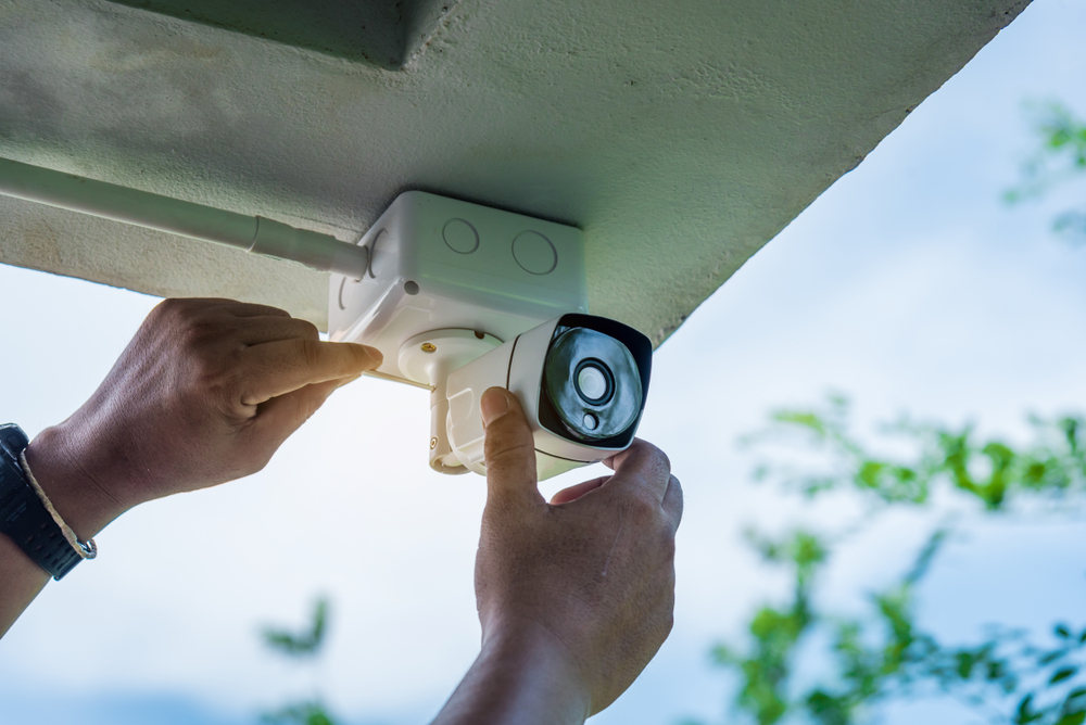 Man installing home security camera (How to Use a Home Security Camera, and How it Could Replace a Video Doorbell)